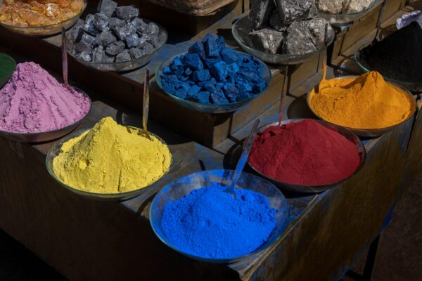 Bowls of colorful powder pigments along with the minerals used to create them.